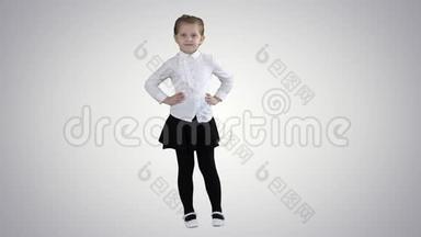 可爱的小女孩穿着白色连衣裙，在渐变背景下的相机上摆姿势。